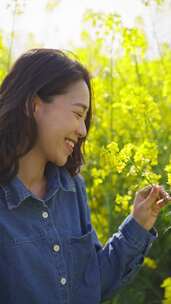 油菜花海里赏花的美女特写春天阳光温暖