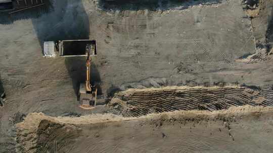 挖掘机将土壤装入自卸卡车