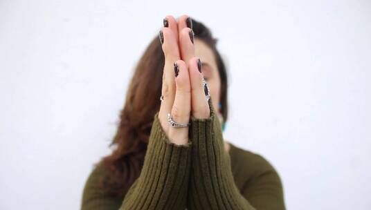 女人用手做了一个祈祷的姿势