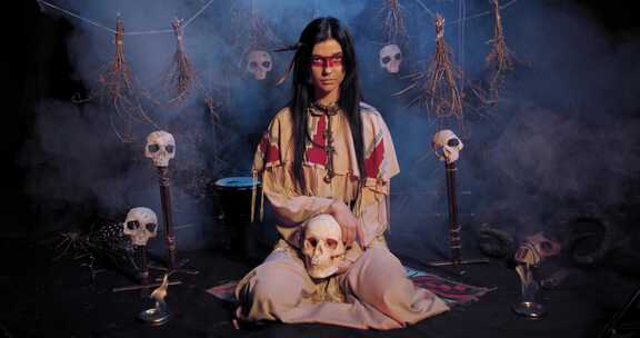穿着传统印第安服装的女人坐在骷髅头旁