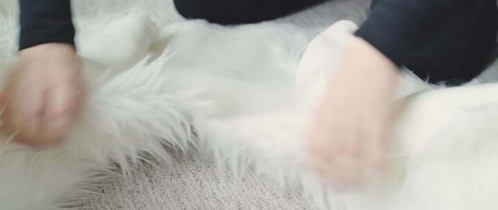 女人坐在地板上撕开毛茸茸的白色材料