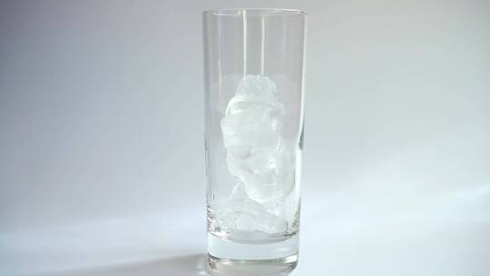 将牛奶倒入玻璃杯_在白色背景上加冰