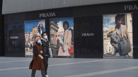 疫情下的成都街头行人戴口罩路过广告牌