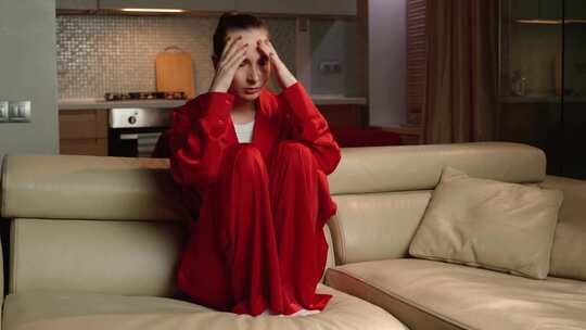 红袍年轻女子晚上在家表达痛苦