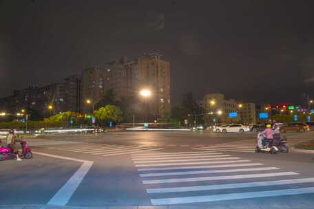 城市四岔路口车流行驶人行道路段夜景延时