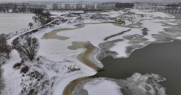 冰雪覆盖的河岸与水中冰块的景象