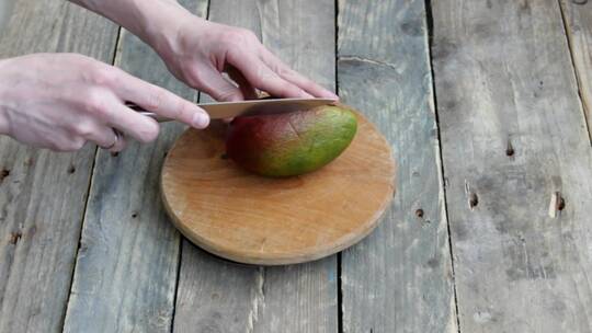 在厨房切了一个起皱的芒果。芒果切成块。