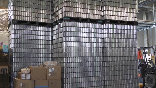 啤酒厂仓库中堆叠的空铝啤酒罐托盘