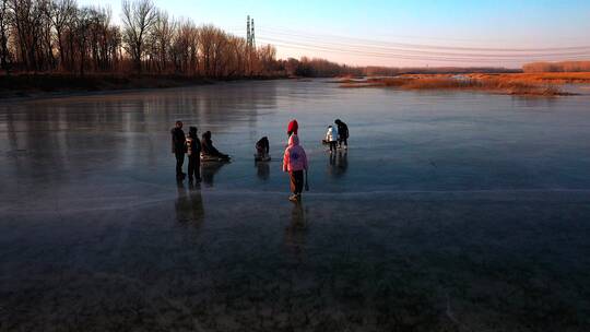 航拍冬季在结冰的河流冰面上滑冰玩耍的游人