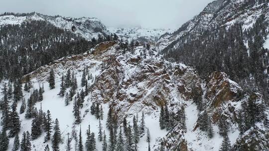 寒冷山区冬季景观中积雪覆盖的岩石山丘的无