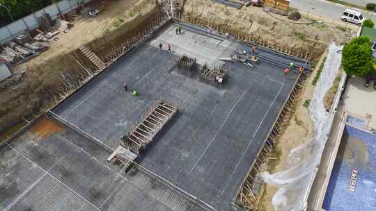 鸟瞰建筑工人弯曲钢筋并铺设地基