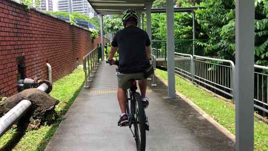 中国男子在有盖道路上骑自行车。慢动作推车