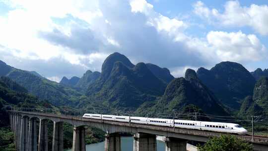 航拍山谷隧道中驶出的高铁列车