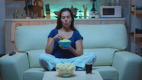 女人在家吃薯片看电影视频素材模板下载
