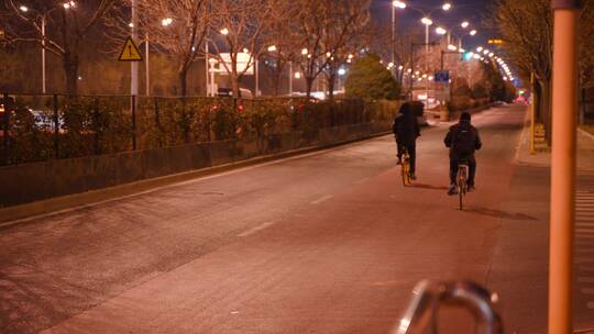 夜晚道路的行人骑自行车下班回家