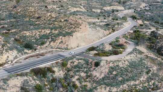 汽车独自行驶在沙地天线旁边的道路上