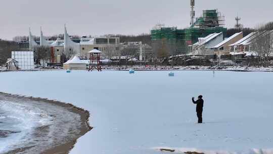 雪地中有人在手持设备进行拍摄