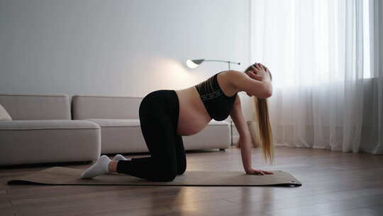 孕妇运动员早上在家训练，以保持怀孕期间的