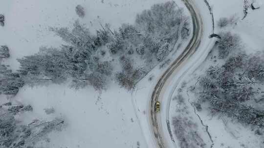 航拍汽车行驶在冬天新疆喀纳斯的山路上视频素材模板下载