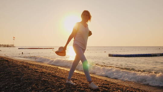 夕阳下在海滩行走的女人视频素材模板下载