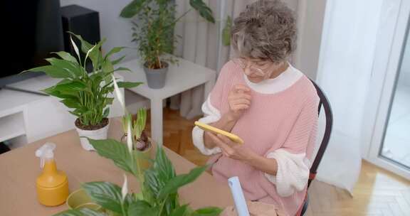 老太太通过电话观看关于花卉种植和园艺的教育视频