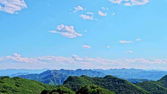 夏季绿色高山蓝天白云与风力发电机组