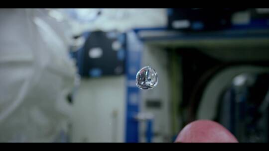 宇航员在太空无重量环境中展示水和液体的特性