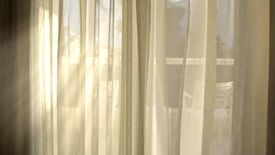 阳光透过白色透明窗帘