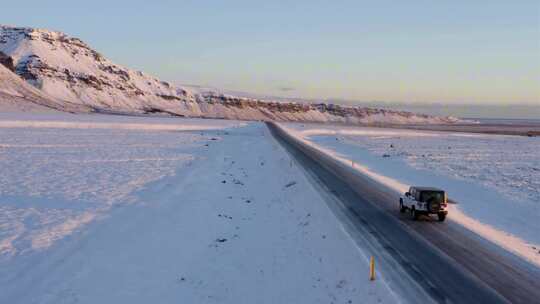 冬天雪山日落夕阳下汽车自驾游自然风景