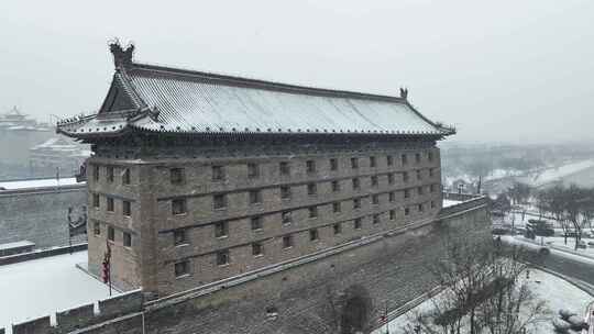 航拍陕西省西安市大雪中的西安安远门古城墙
