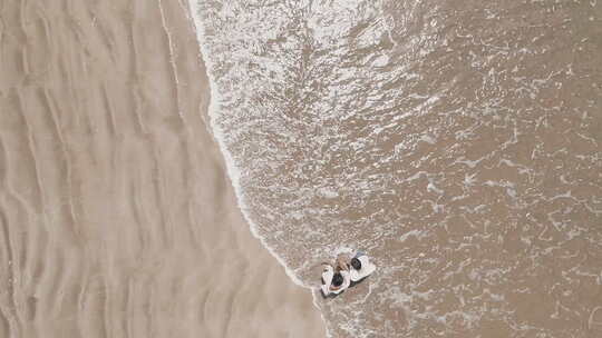 鸟瞰夫妇走在沙滩上视频素材模板下载