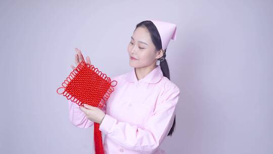 年轻女护士装手持中国结