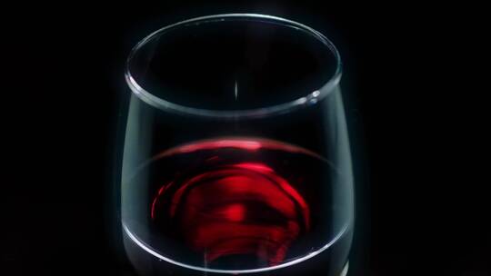 黑色背景上有红酒的玻璃杯