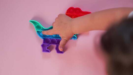 彩虹颜色和迪诺形状的Popit彩虹玩具