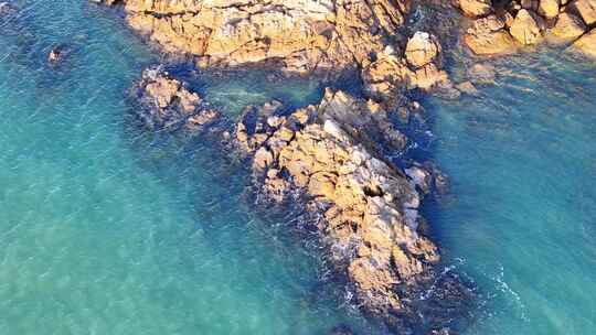 空中俯瞰岩石海岸边的碧绿海水