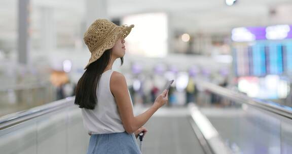 拿着手机站在电梯上的女人