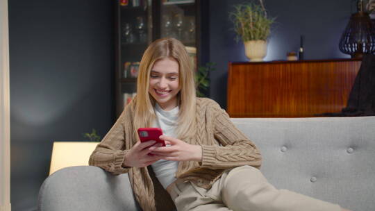夜幕下坐在沙发上玩手机的女人视频素材模板下载
