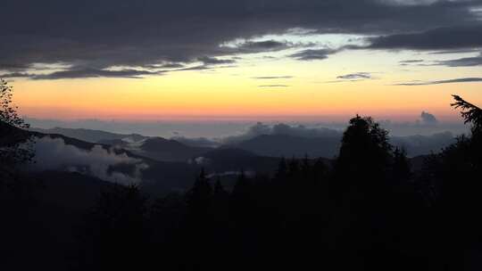 日出前山顶翻滚的雾气剪影