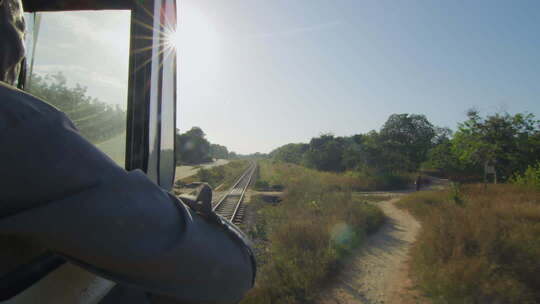 非洲坦赞铁路上行驶的火车阳光下的火车轨道与绿色植被