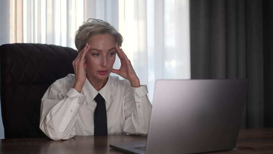 忧心忡忡的女企业家肖像在笔记本电脑上阅读
