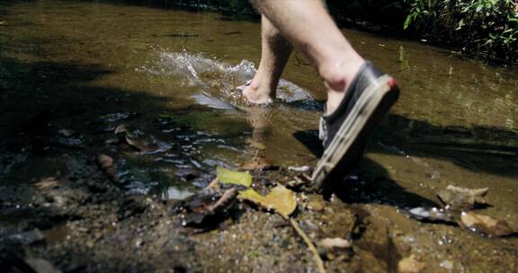 穿胶鞋的人走在一条浅河里
