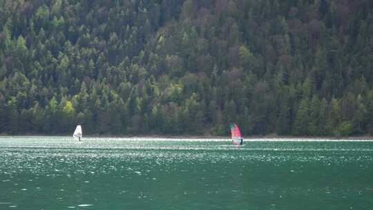 在山上的阿琴湖上滑浪风帆。奥地利阿尔卑斯山的水上运动。