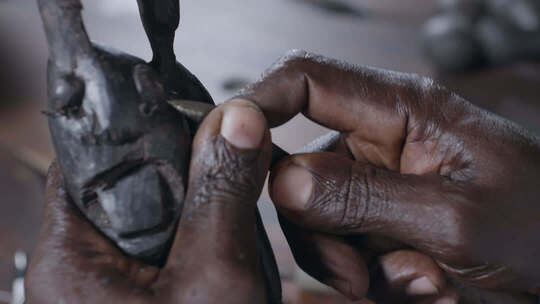 非洲坦桑尼亚老人专注雕刻木器