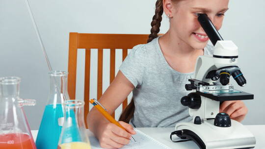 女孩使用显微镜观察