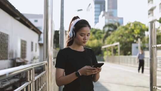 女人，智能手机，听音乐，人行道