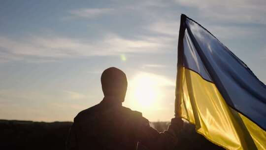 乌克兰陆军男性士兵举起蓝洛旗帜纪念战胜俄