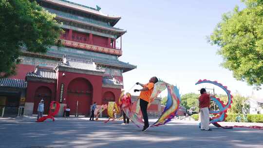 北京早晨舞彩带龙的老年人市民