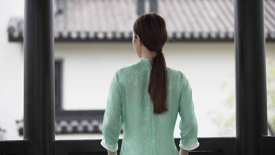 年轻旗袍女子中式合院门廊护栏边休息