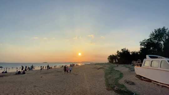 夕阳下热闹的海边沙滩景象