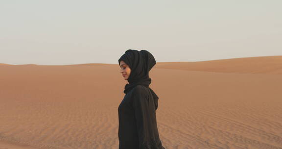 穆斯林女人在沙漠中行走